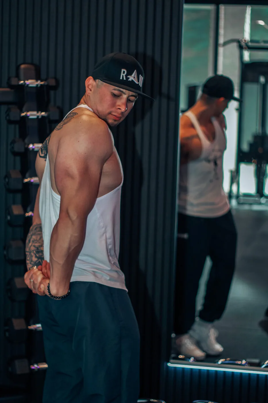 Portret van een gespierde man met pet in de gym